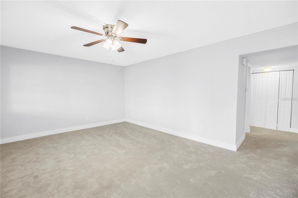 4700 Cove Circle, Unit 103 St. Petersburg, FL 33708 - Photo 18 of 31 an empty room with chandelier fan and windows