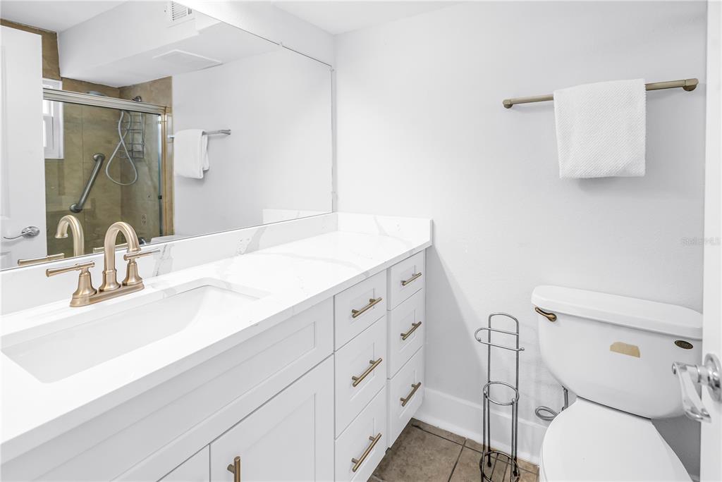 4700 Cove Circle, Unit 103 St. Petersburg, FL 33708 - Photo 24 of 31 a bathroom with a sink mirror vanity and toilet