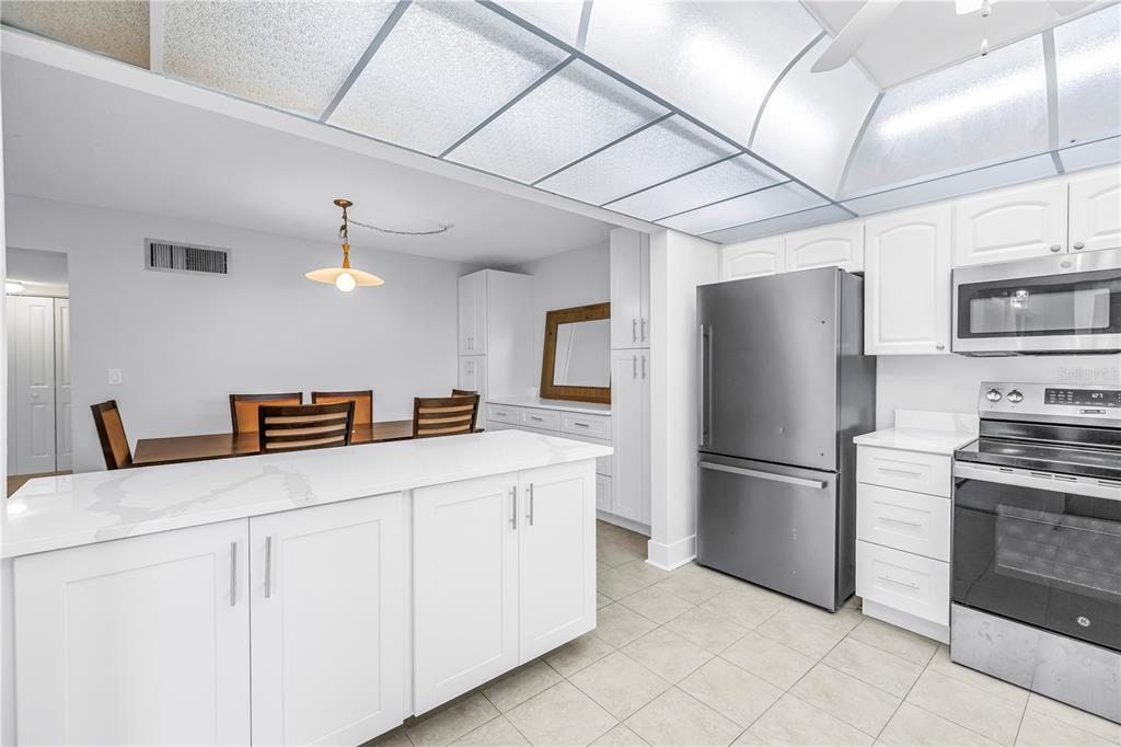 4700 Cove Circle, Unit 103 St. Petersburg, FL 33708 - Photo 8 of 31 a kitchen with stainless steel appliances a refrigerator and a stove top oven