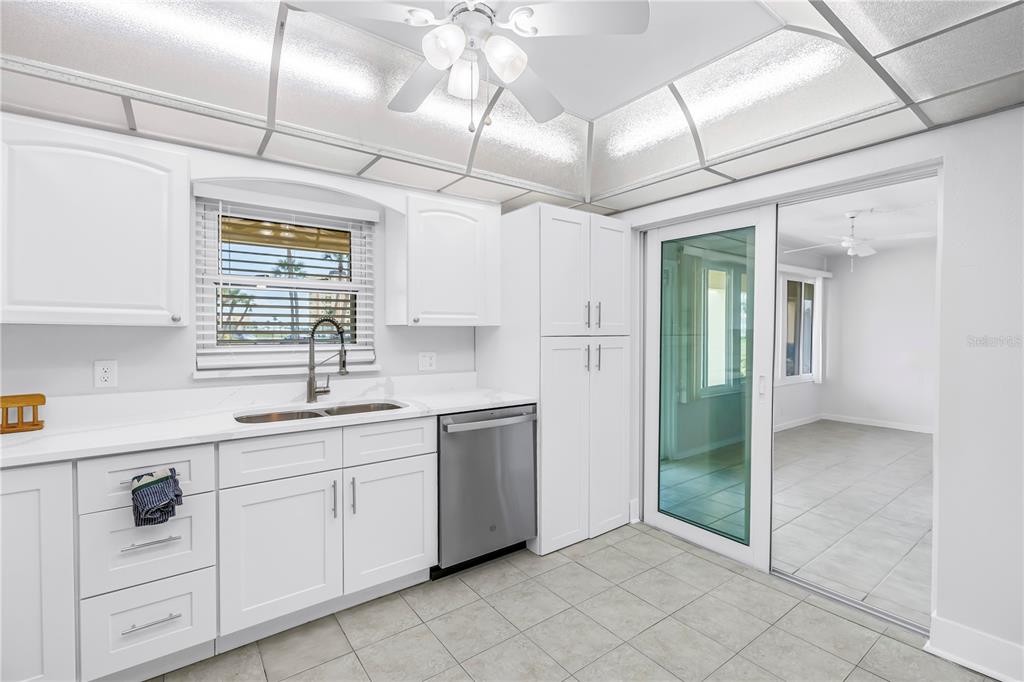 4700 Cove Circle, Unit 103 St. Petersburg, FL 33708 - Photo 9 of 31 a kitchen with white cabinets a sink and appliances