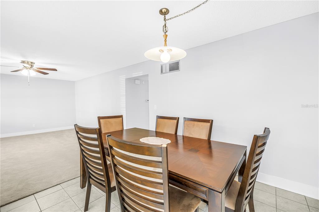 4700 Cove Circle, Unit 103 St. Petersburg, FL 33708 - Photo 10 of 31 a view of a dining room with furniture and wooden floor