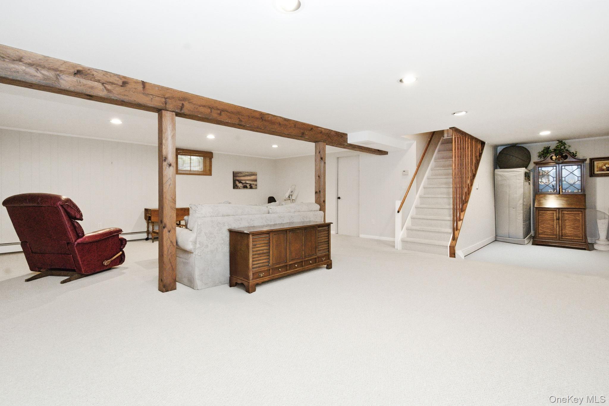 32 Bedell Road Katonah, NY 10536 - Photo 29 of 49 Rustic wood beams lend character to the lower level rec space, with the workshop area just beyond.