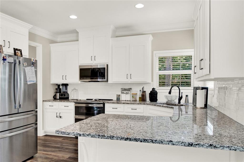 407 Corinth Church Road Winder, GA 30680 - Photo 20 of 66 a kitchen with stainless steel appliances granite countertop a sink stove microwave and refrigerator