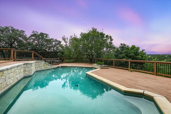 a view of swimming pool with lawn chairs and plants