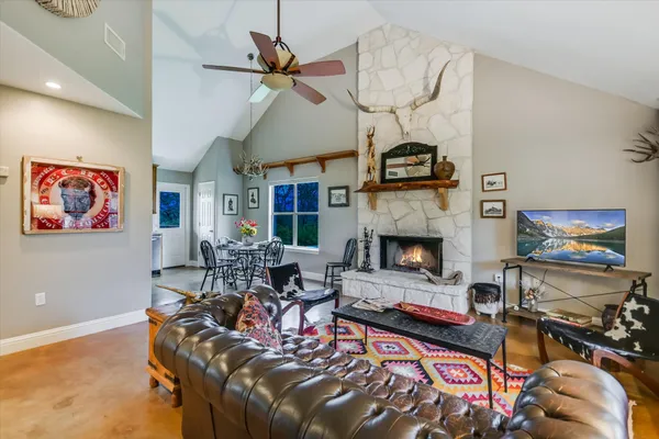 a kitchen with stainless steel appliances granite countertop a stove a refrigerator a kitchen island a table and chairs