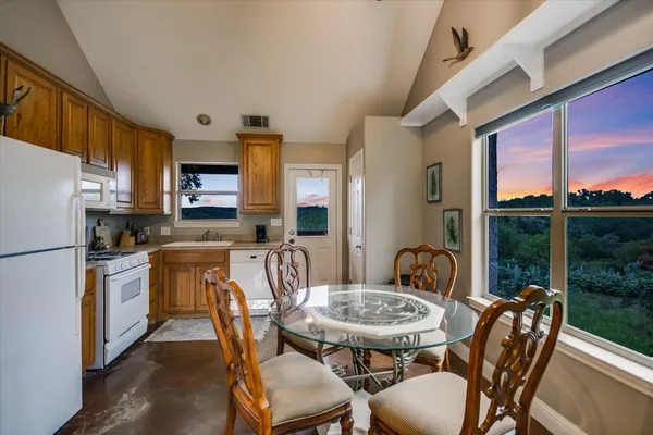 a living room with furniture kitchen view and a chandelier