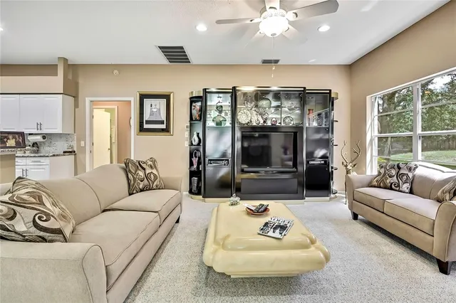 a living room with furniture ceiling fan and a flat screen tv