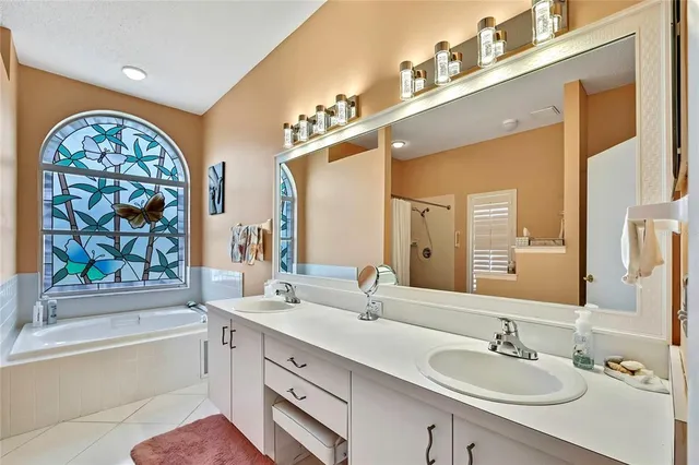 a bathroom with double vanity and a mirror