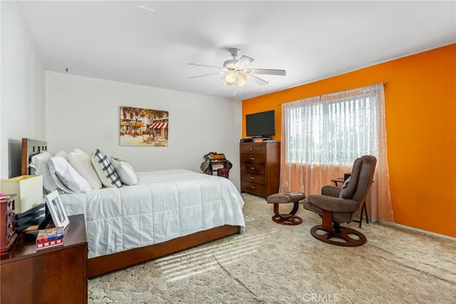 a bedroom with a bed a dresser and chair