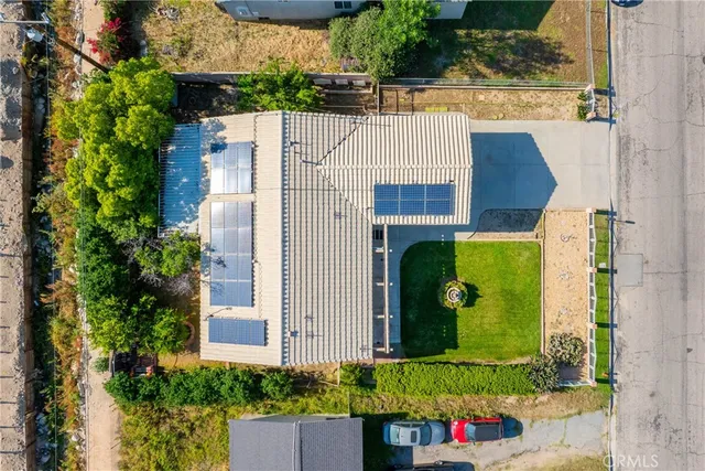an aerial view of a house with a yard and potted plants
