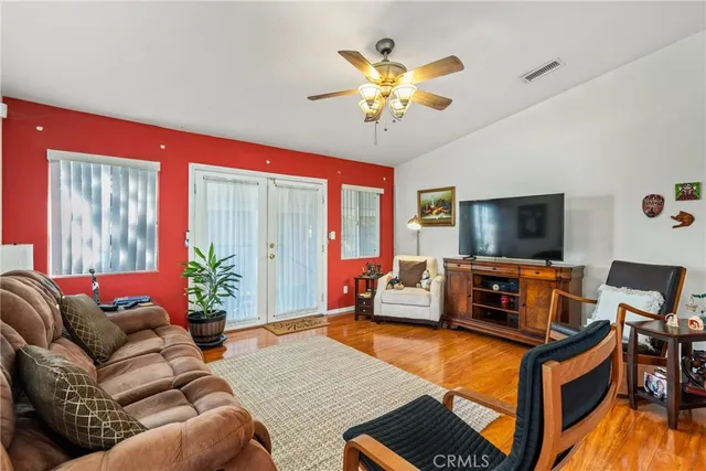 a living room with furniture a flat screen tv and a chandelier