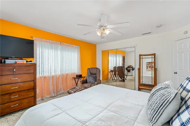 a bedroom with a bed and dresser with mirror