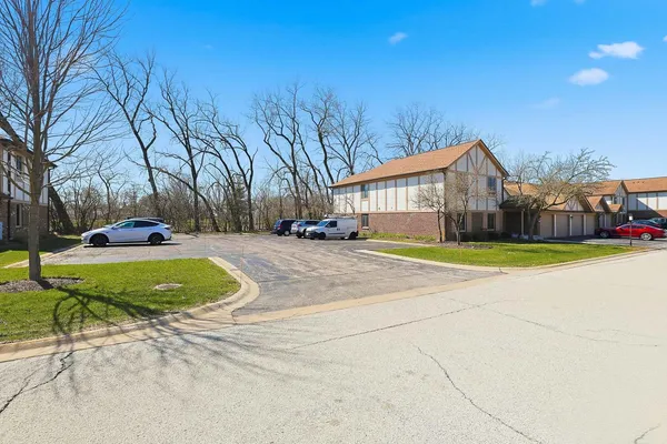 a view of a house with a big yard and large trees
