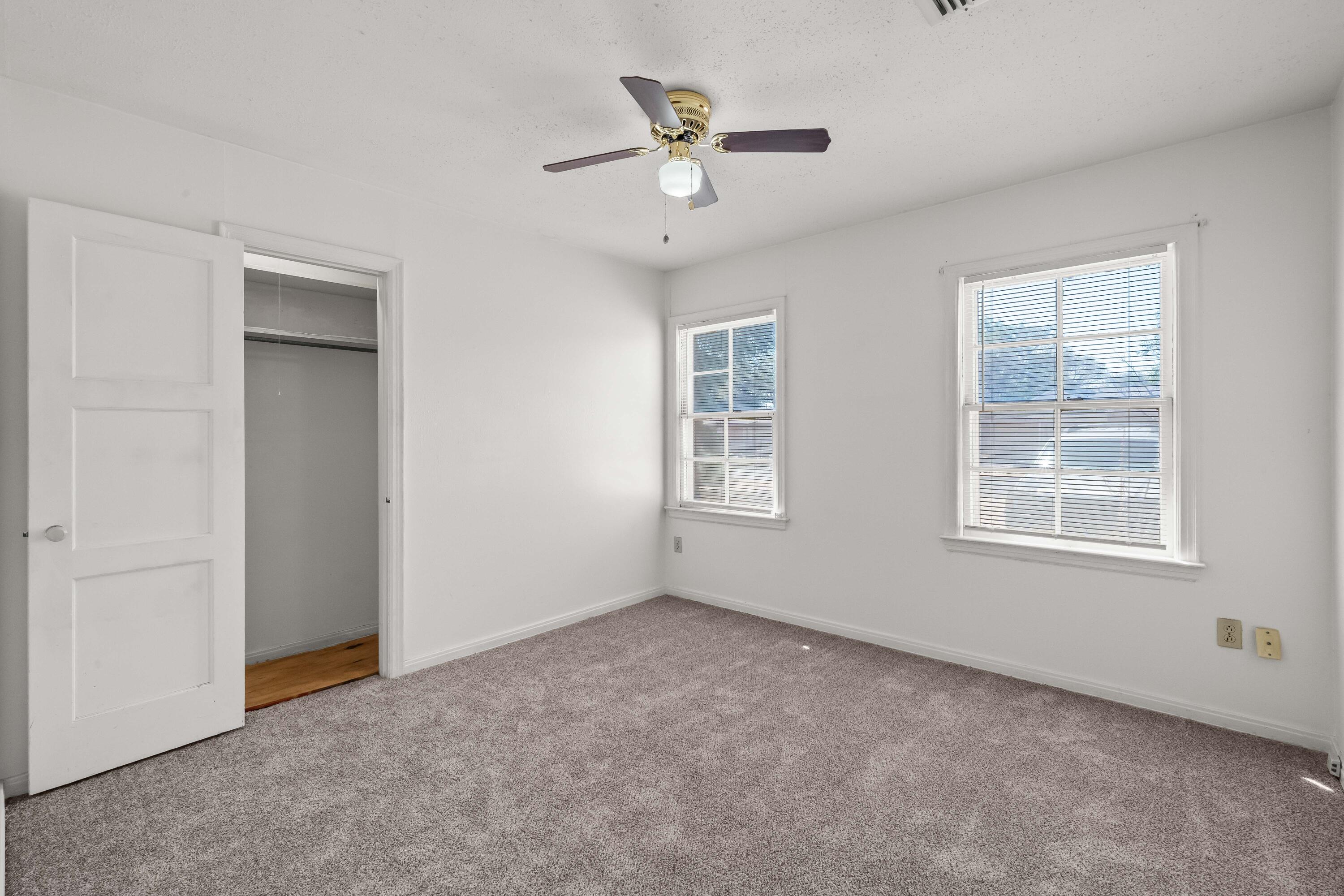 1718 46th Street Lubbock, TX 79412 - Photo 12 of 17 an empty room with windows and a ceiling fan
