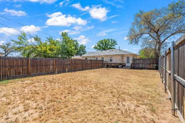 a view of a backyard with wooden fence