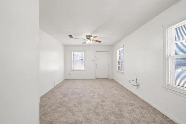 an empty room with windows and closet