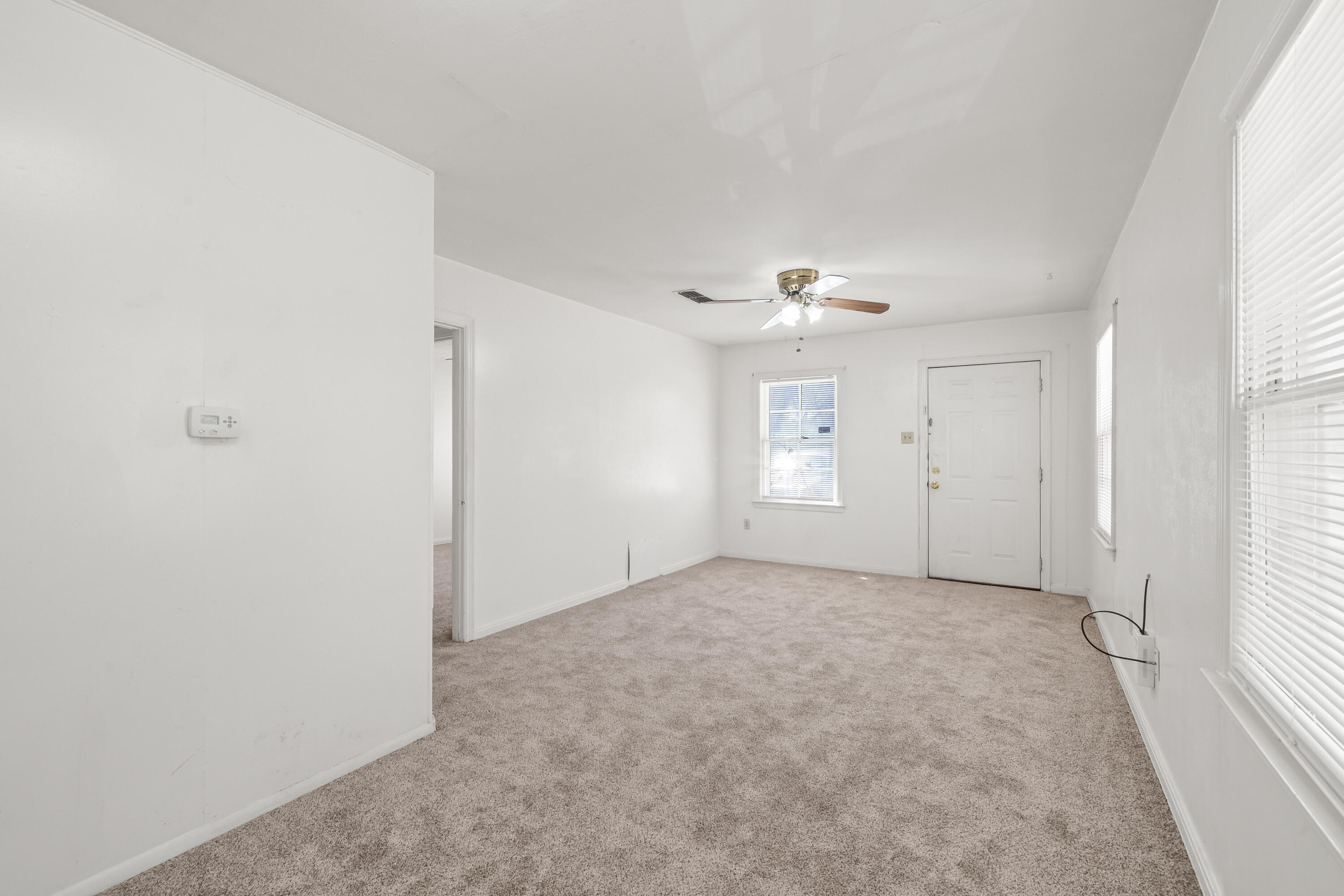 1718 46th Street Lubbock, TX 79412 - Photo 4 of 17 an empty room with windows and cabinet
