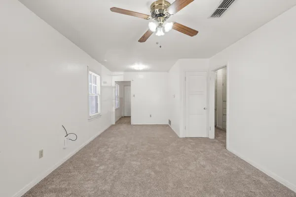 an empty room with chandelier fan