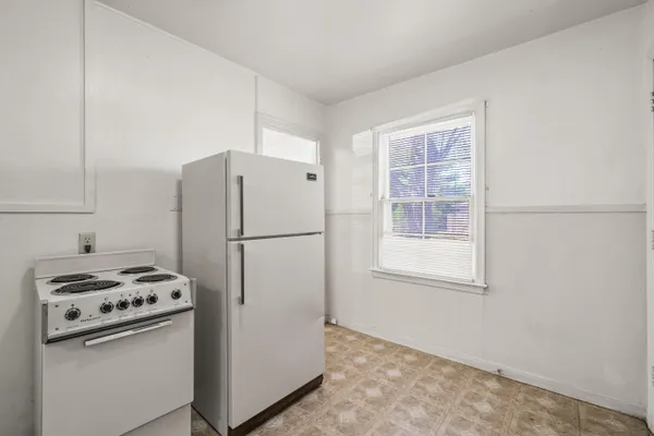 a kitchen with a refrigerator a stove a sink and a window