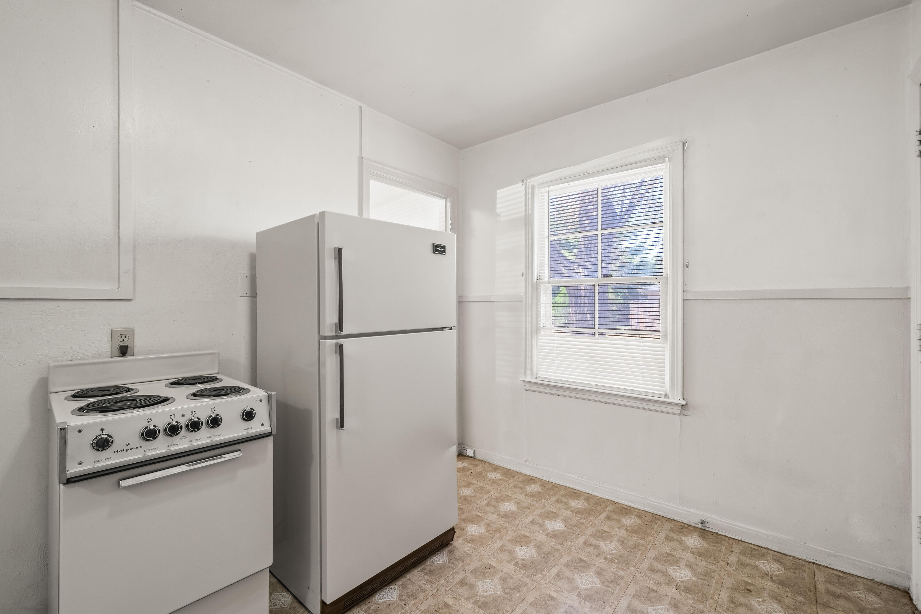 1718 46th Street Lubbock, TX 79412 - Photo 9 of 17 a kitchen with a refrigerator a stove a sink and a window