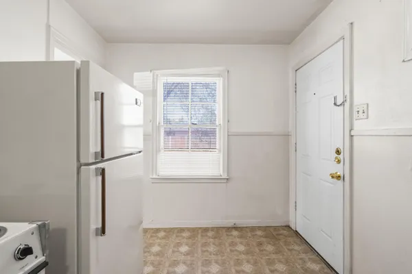 a view of kitchen with a refrigerator cabinet and a window