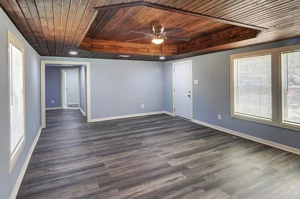 en empty room with wooden floor and windows
