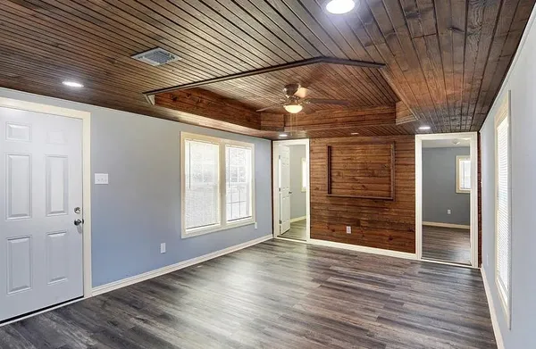 an empty room with wooden floor and windows