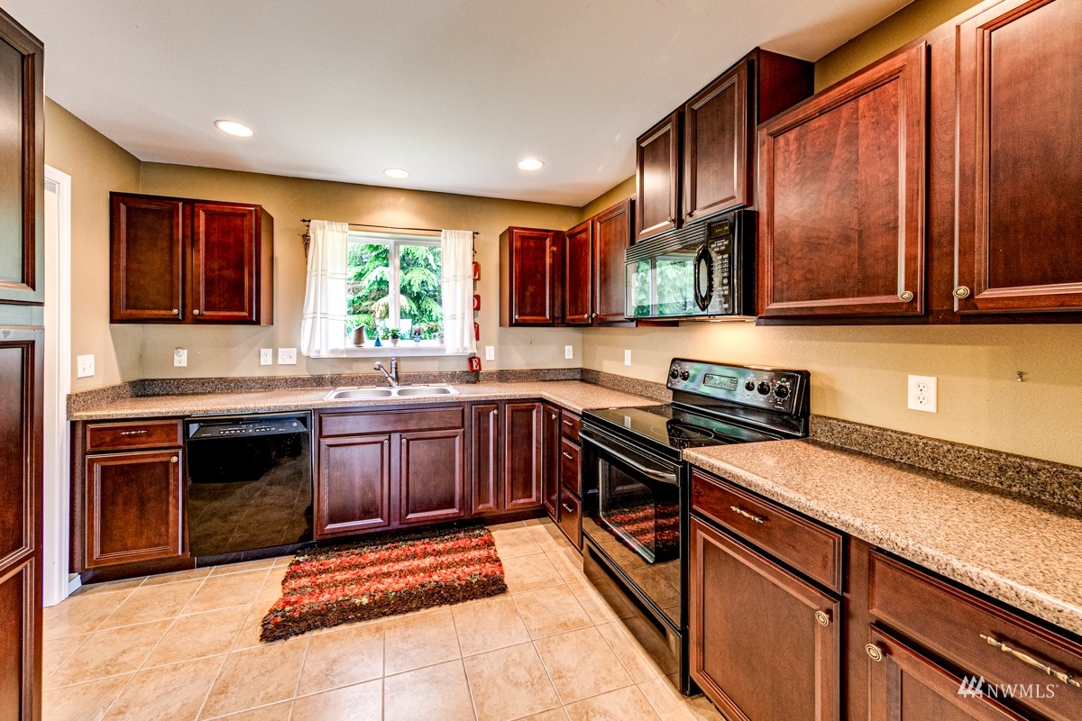 976 Township Line Road Port Angeles, WA 98362 - Photo 16 of 40 a kitchen with stainless steel appliances granite countertop wooden cabinets a stove top oven a sink and dishwasher