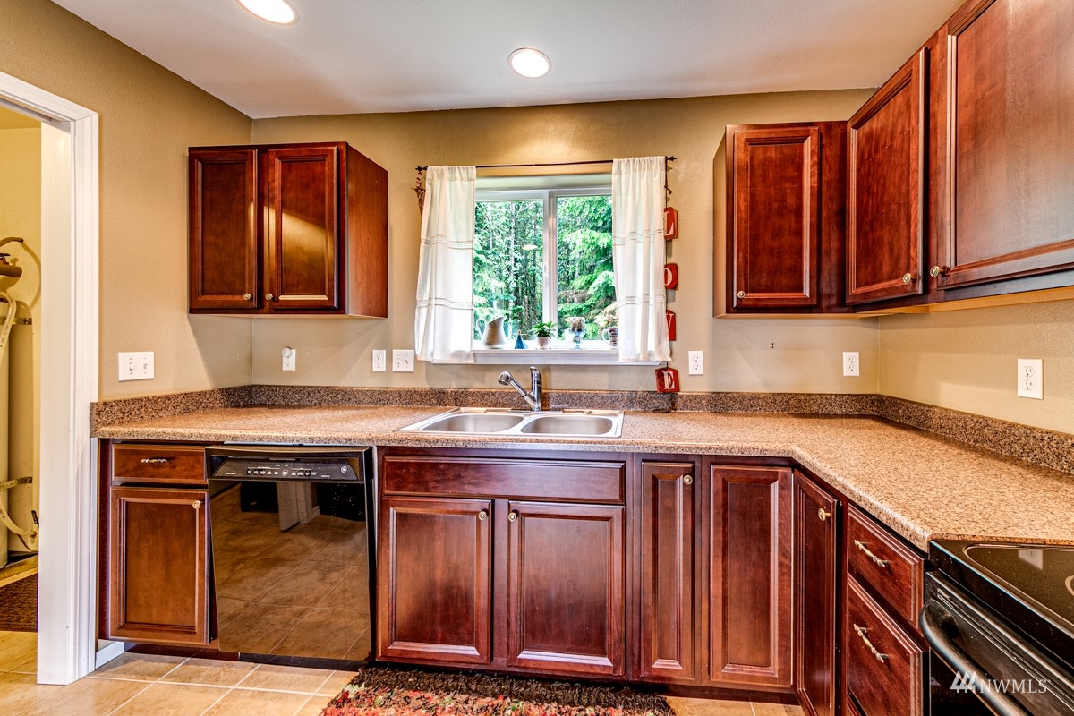 976 Township Line Road Port Angeles, WA 98362 - Photo 17 of 40 a kitchen with stainless steel appliances granite countertop wooden cabinets a sink and a window