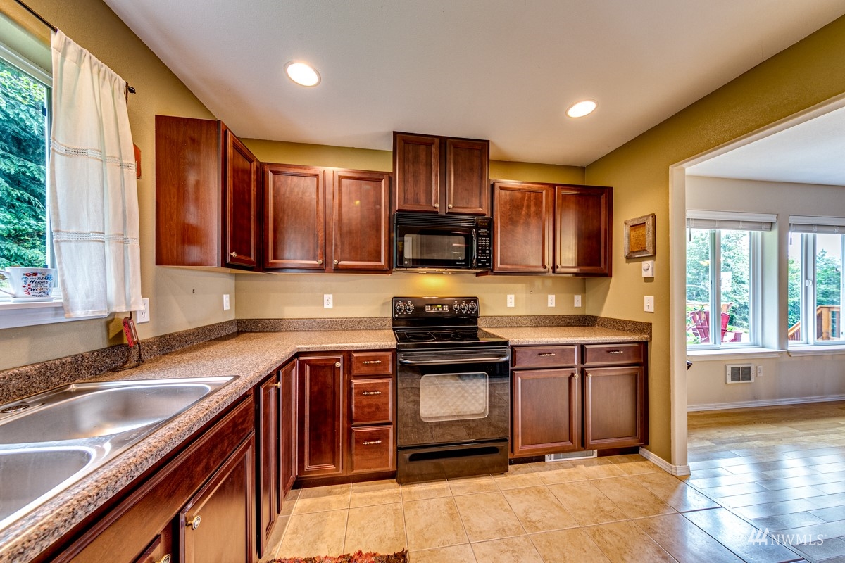 976 Township Line Road Port Angeles, WA 98362 - Photo 18 of 40 a kitchen with granite countertop wooden cabinets a sink and a stove
