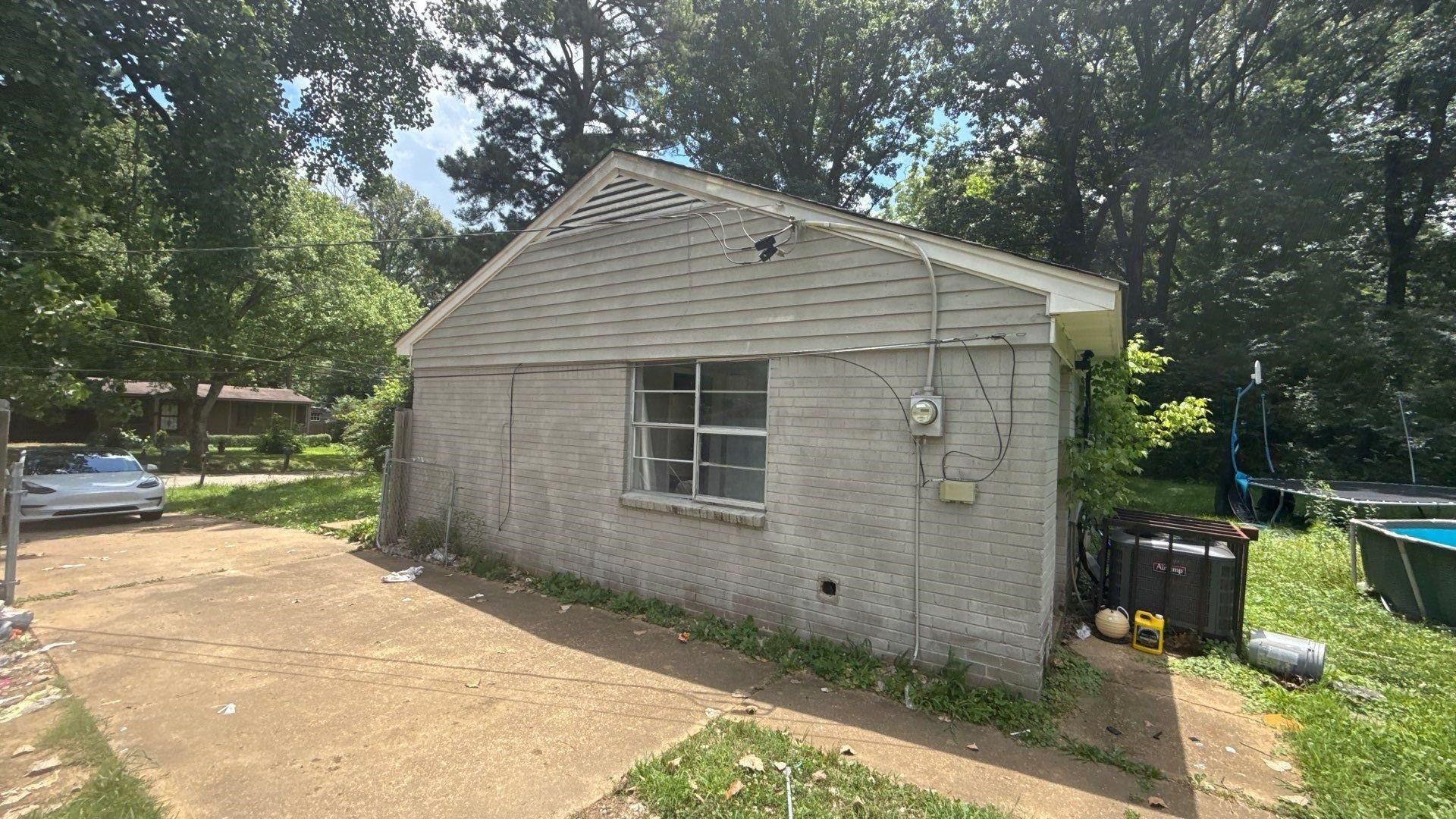 4939 Manson Road Memphis, TN 38109 - Photo 14 of 17 Gray brick exterior with a contrasting light-colored gable and siding