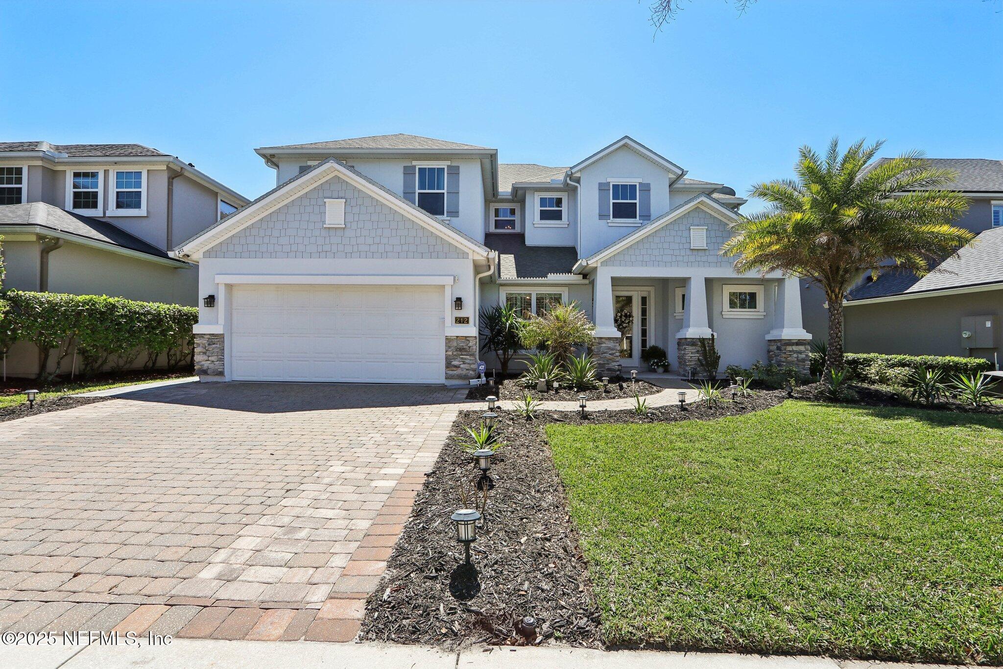 a front view of a house with yard and green space