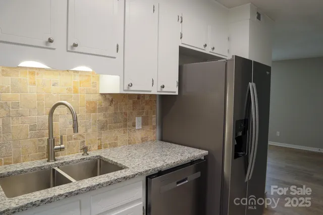 a kitchen with stainless steel appliances granite countertop a refrigerator and a sink