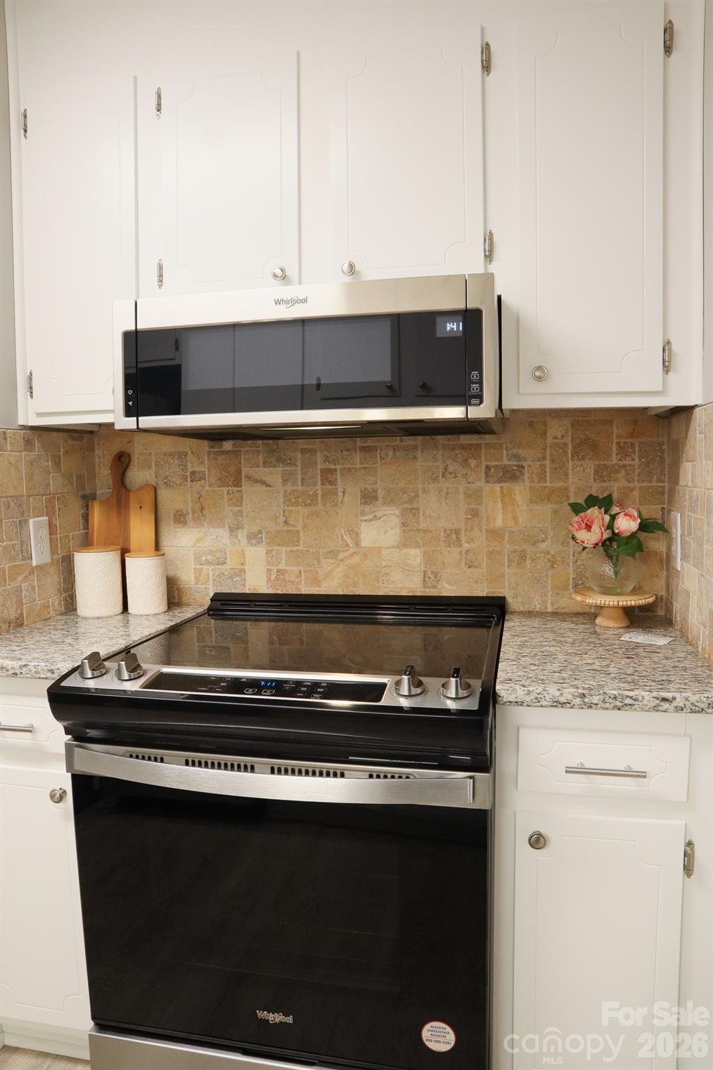525 12th Street Southwest, Unit 26 Hickory, NC 28602 - Photo 8 of 21 a kitchen with stainless steel appliances granite countertop a stove a sink and white cabinets