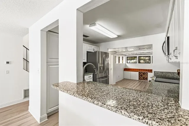 a kitchen with stainless steel appliances granite countertop a sink stove and cabinets