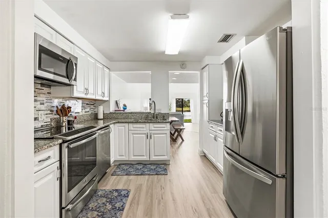 a kitchen with stainless steel appliances a refrigerator sink and microwave