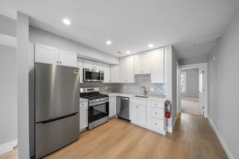 a kitchen with stainless steel appliances granite countertop a stove a sink and a refrigerator