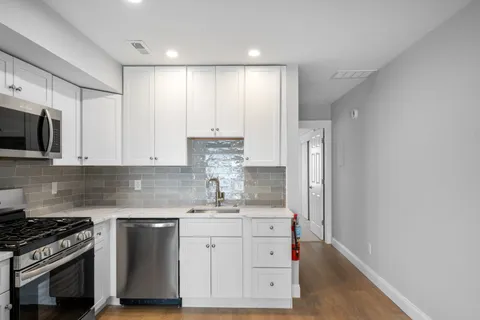 a view of a kitchen with a sink hardwood floor and a window