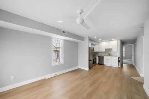 a view of a kitchen with refrigerator and wooden floor