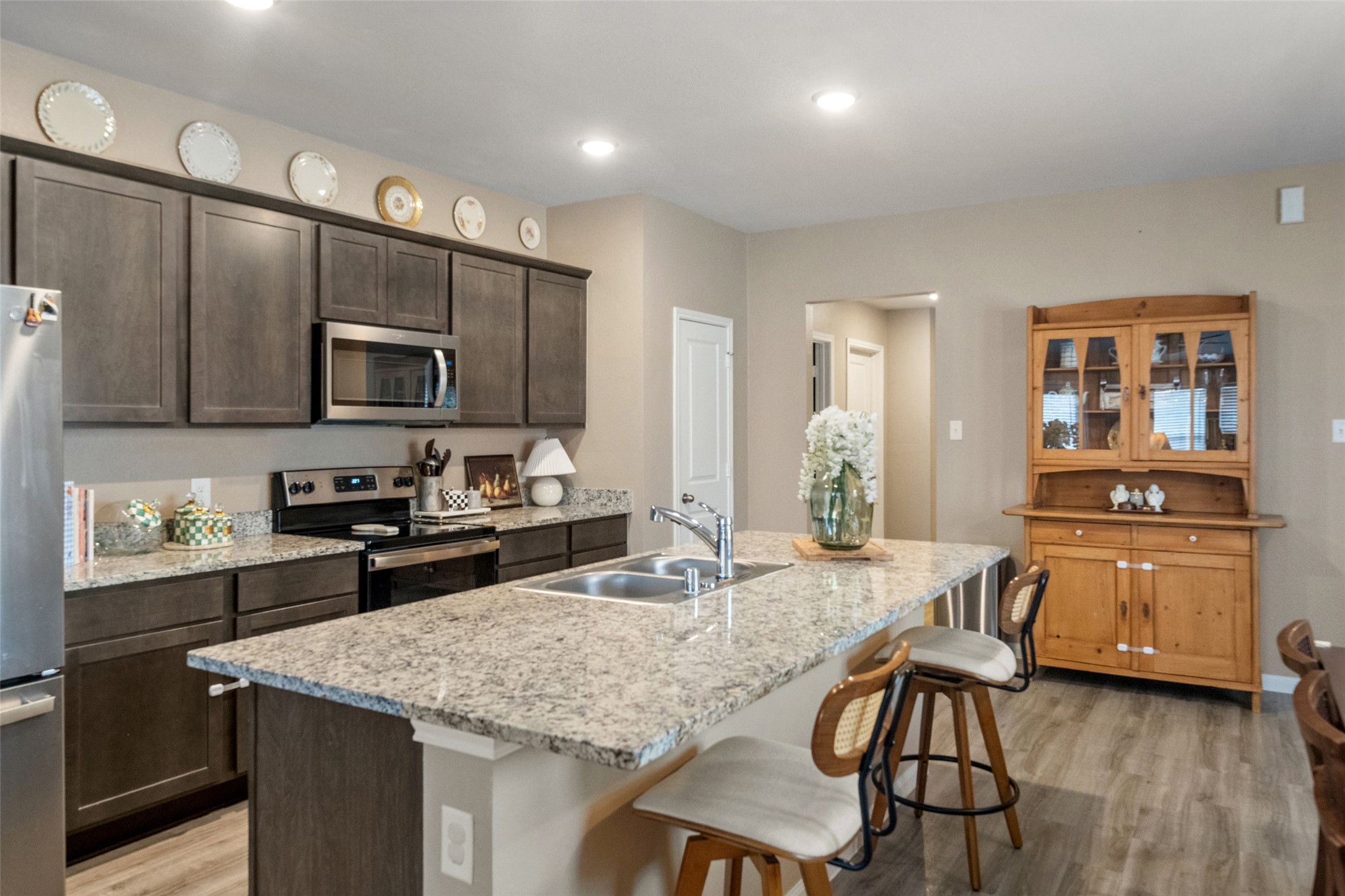 26431 Pin Oak Drive Hempstead, TX 77445 - Photo 12 of 32 Kitchen and dining view highlighting the island seating and roomy layout—perfect for gatherings and everyday use. Modern finishes and a clean, neutral palette keep the space bright and timeless.