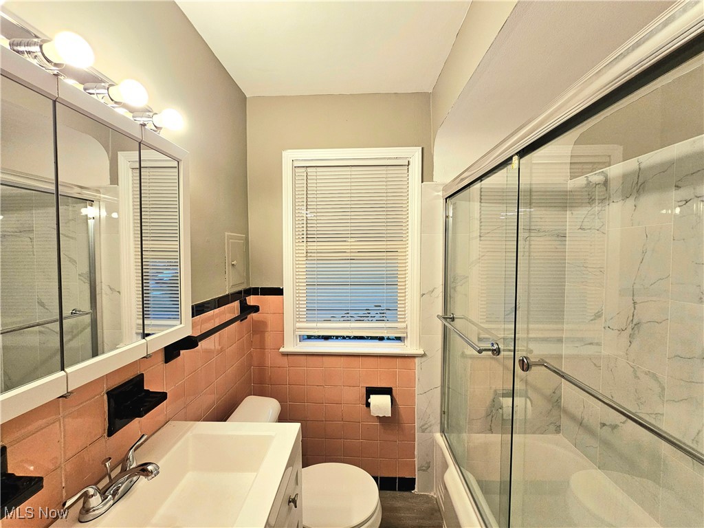 13514 Granger Road Cleveland, OH 44125 - Photo 18 of 23 Bathroom featuring tile walls, vanity, and toilet