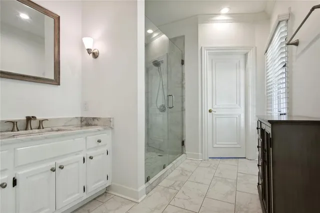 a bathroom with a granite countertop sink a mirror and a shower