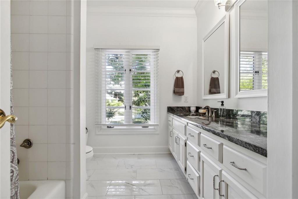 2760 Carmon On Wesley Northwest Atlanta, GA 30327 - Photo 26 of 30 a bathroom with a granite countertop sink a mirror and a bathtub