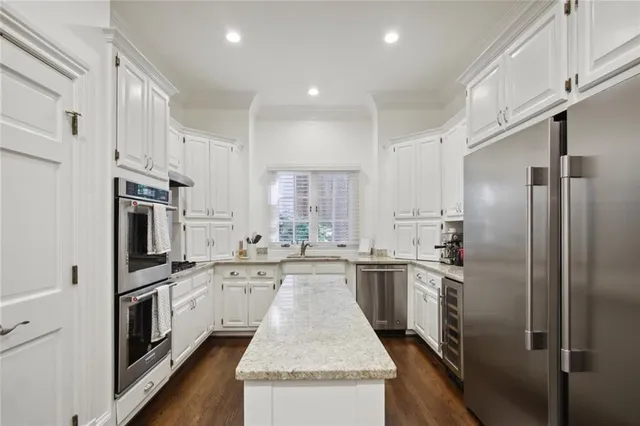 a large kitchen with stainless steel appliances kitchen island a sink stove and refrigerator