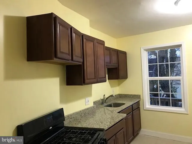 a kitchen with granite countertop a stove and a sink