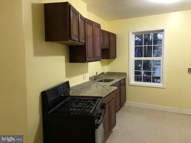 3010 Overland Avenue Baltimore, MD 21214 - Photo 2 of 11 a kitchen with granite countertop a stove and a sink