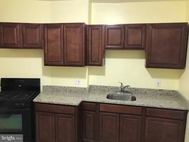 a kitchen with wooden cabinets a sink and a stove