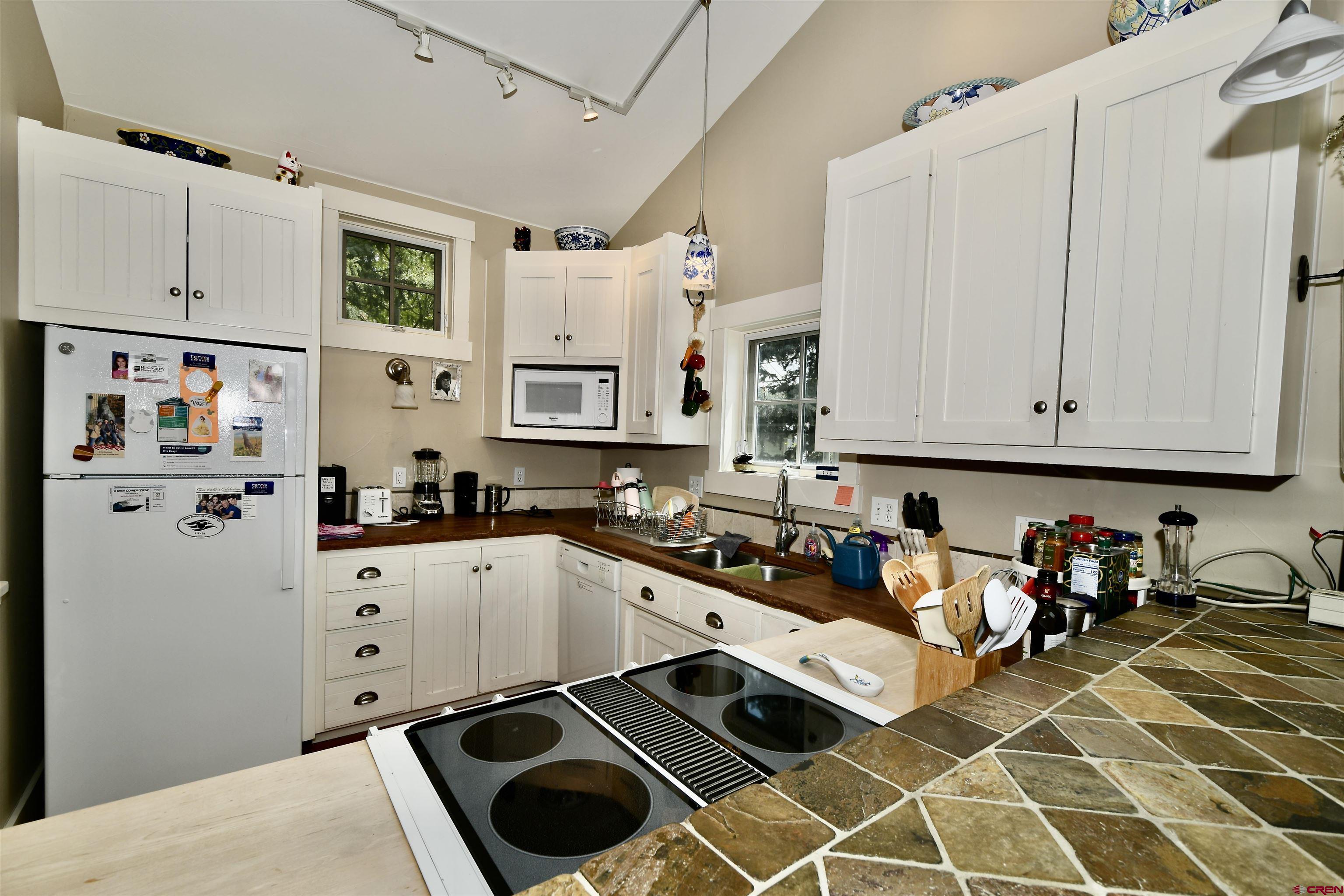 602-604 4th Street Crested Butte, CO 81224 - Photo 11 of 45 a kitchen with stainless steel appliances a stove a sink and white cabinets