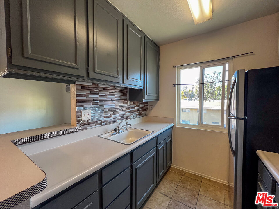17900 Sherman Way, Unit 320 Reseda, CA 91335 - Photo 6 of 19 a kitchen with a sink refrigerator and window