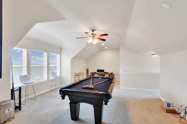 a room with pool table and windows